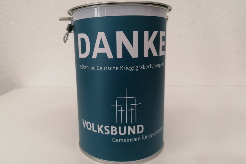 Eine dunkelblaue Sammeldose des VDK. Darauf die Aufschrift "DANKE - Volksbund Deutsche Kriegsgräberfürsorge - Gemeinsam für den Frieden"