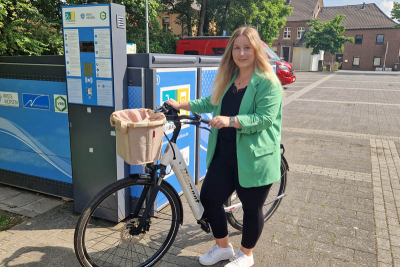 Elisabeth Mevißen mit einem weiß-schwarzen Fahrrad vor der Radschloss-Radbox am Lindbruch in Niederkrüchten